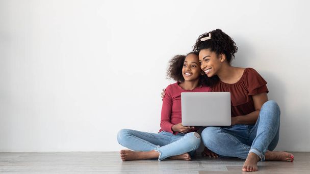 Happy black mom and teen kid using laptop, copy space - Photo, Image