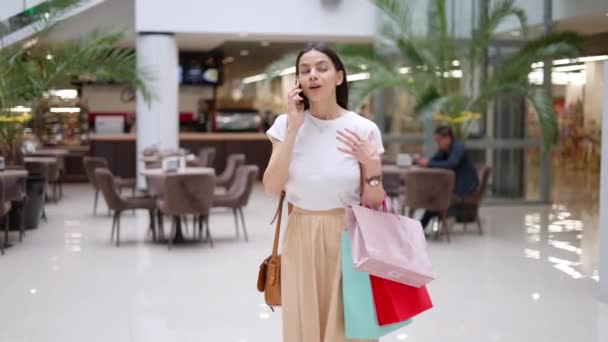 Female shopaholic bragging about her purchases in mall during seasonal sales - Footage, Video