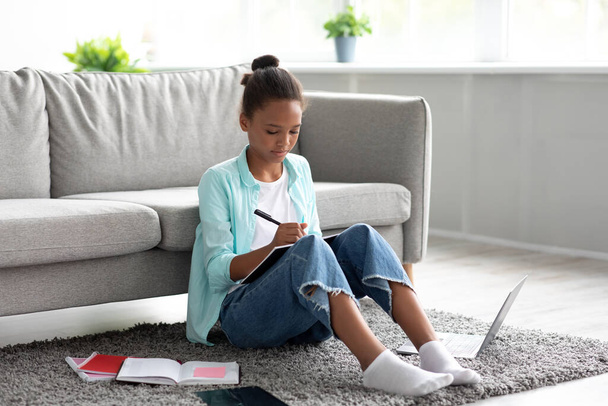 Pensive geconcentreerde tiener afro-Amerikaanse meisje student studeren thuis met laptop, voor te bereiden op de test - Foto, afbeelding