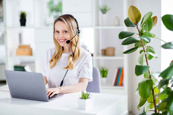 Profile side photo of young woman happy positive smile wear headphones remote work manager call center computer type indoors - Fotoğraf, Görsel