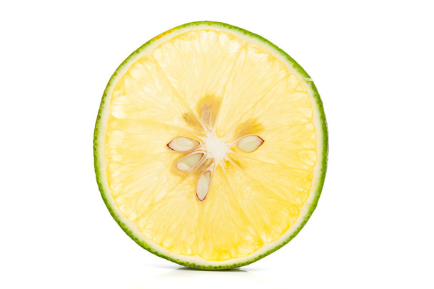Ekstremalne makro zbliżenie organicznych owoców cytrusowych słodkiego limetta lub mosambi (Citrus limetta) w plasterkach część pokazuje gruczoły sokowe i nasiona, światło przechodzi przez plasterek, jest zielony i żółty w kolorze, izolowane na białym tle - Zdjęcie, obraz