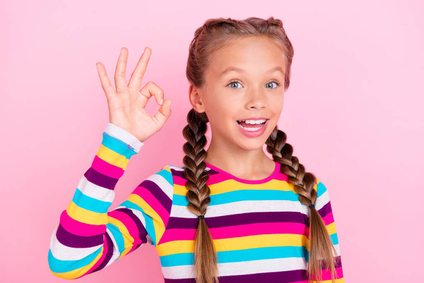 Фото веселих позитивних маленьких жіночих пальців показують знак джакузі у смугастій сорочці ізольований рожевий кольоровий фон
 - Фото, зображення