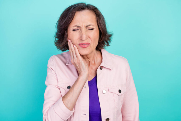 Photo portrait woman in casual clothes suffering from tooth ache need go to dentist isolated vibrant teal color background - 写真・画像
