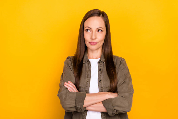 Photo of dreamy minded confident young woman hold hands folded look empty space isolated on yellow color background - Valokuva, kuva