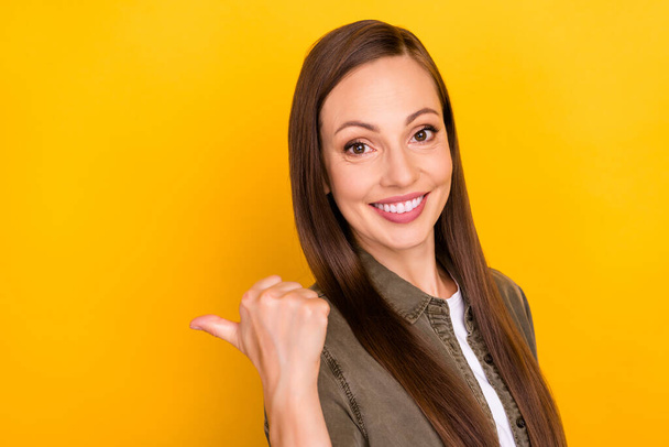 Photo of attractive positive young woman point finger empty space index sale isolated on yellow color background - Foto, immagini