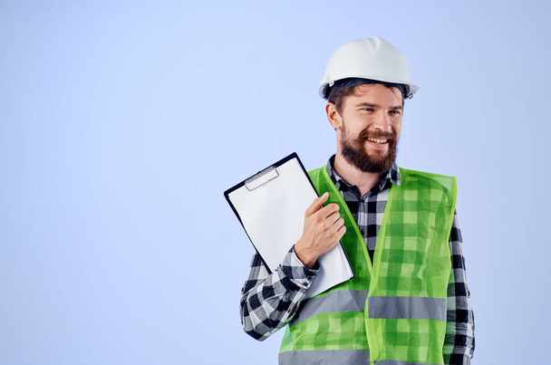 constructor masculino en un verde vestconstruction trabajo diseño fondo azul - Foto, imagen