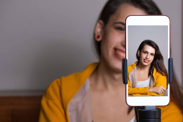 幸せな女性vloggerライブスマートフォンを使用してリビングルームからストリーミング - 写真・画像