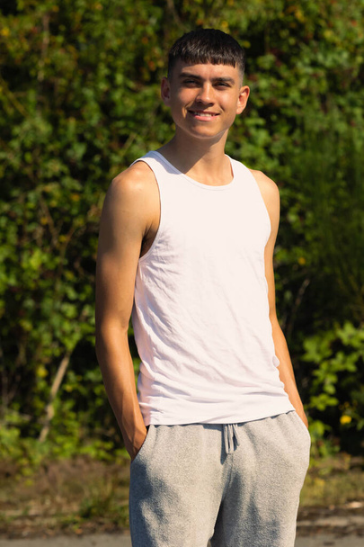 An 18 year old teen boy in a sleeveless top on a late summer's day - Foto, Imagem