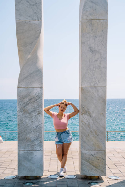young blonde woman poses between two columns - Фото, зображення