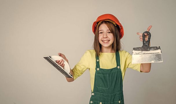 girl kid in hard hat on construction site use spatula, equipment - Фото, зображення