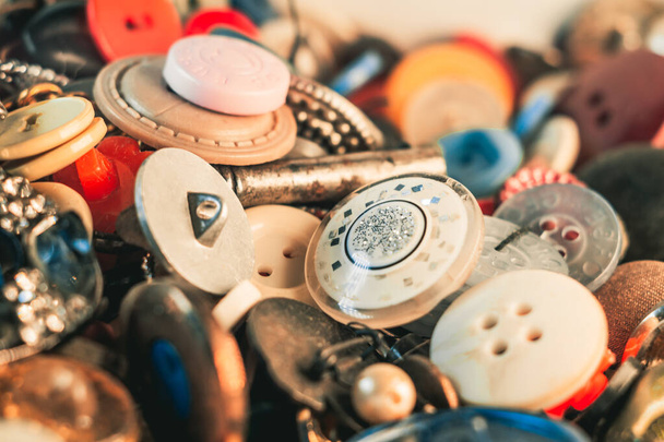 Um tiro de foco seletivo de botões coloridos de diferentes tamanhos e materiais de costura - Foto, Imagem