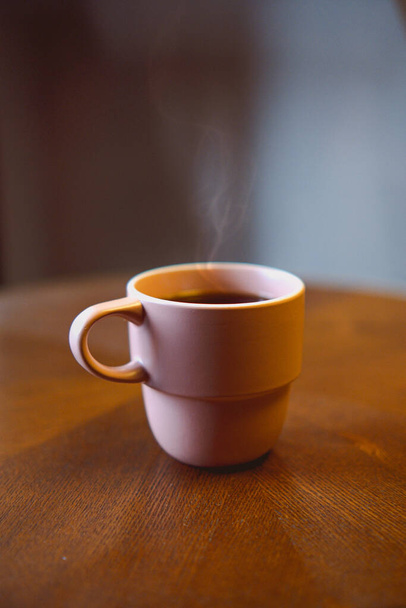 A cup of fresh coffee on a wooden table - Fotoğraf, Görsel