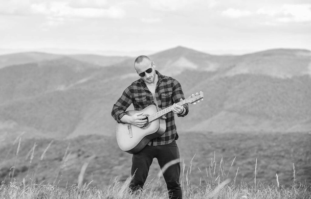Bring music to life. cowboy man with acoustic guitar player. country music song. sexy man with guitar in checkered shirt. hipster fashion. western camping and hiking. happy and free - 写真・画像