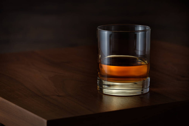 A tumbler glass with a luxurious whiskey on wooden table - Zdjęcie, obraz