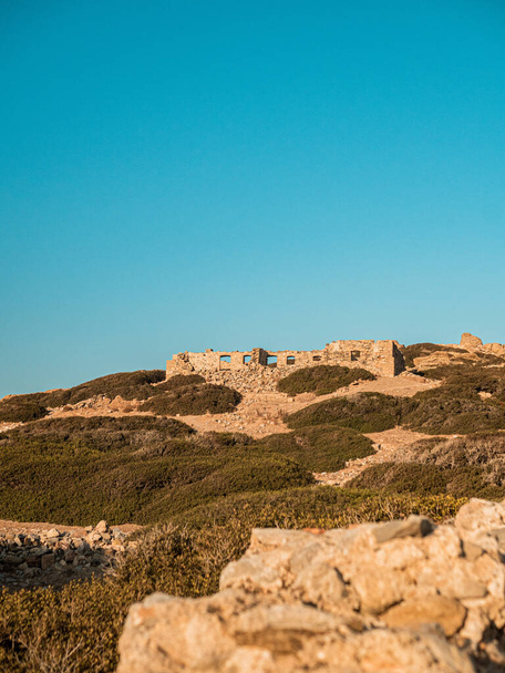 A vertical shot of ruined castle on the hillside against blue sky - Foto, afbeelding