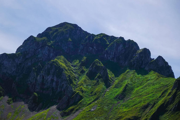 alta montagna rocciosa verde con cielo blu durante le escursioni in estate in vacanza - Foto, immagini