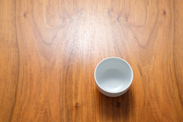 A top view of an empty white minimalistic cup on a wooden table with a copy space - Fotoğraf, Görsel