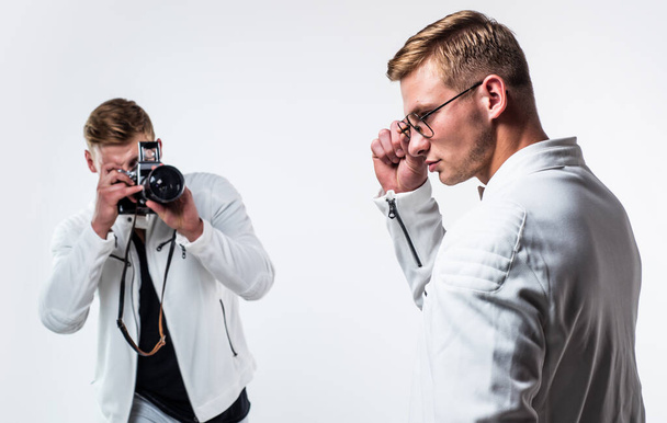 twin brothers men photographer in white casual look alike use vintage photo camera, photographing. - Foto, imagen