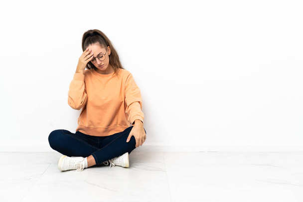 Молодая женщина сидит на полу с головной болью - Фото, изображение