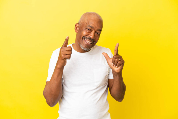 cubano anziano isolato su sfondo giallo dando un pollice in su gesto - Foto, immagini