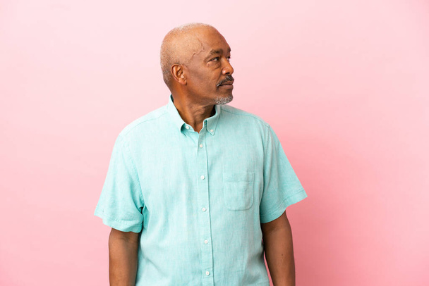 Cuban senior isolated on pink background looking to the side - Zdjęcie, obraz