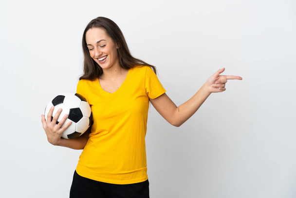 Jovem jogador de futebol mulher sobre fundo branco isolado apontando o dedo para o lado e apresentando um produto - Foto, Imagem