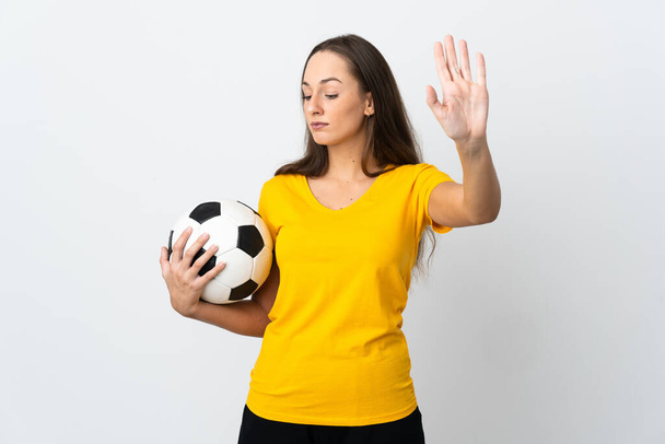 Young football player woman over isolated white background making stop gesture and disappointed - Foto, afbeelding