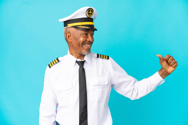 pilot samolotu senior człowiek izolowany na niebieskim tle dumny i zadowolony z siebie - Zdjęcie, obraz