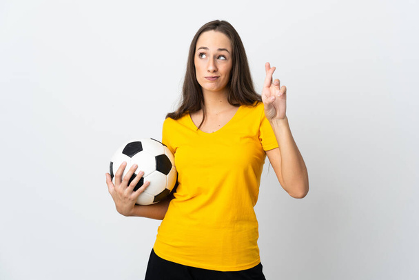 Молодая футболистка на изолированном белом фоне со скрещиванием пальцев и пожеланиями всего наилучшего - Фото, изображение