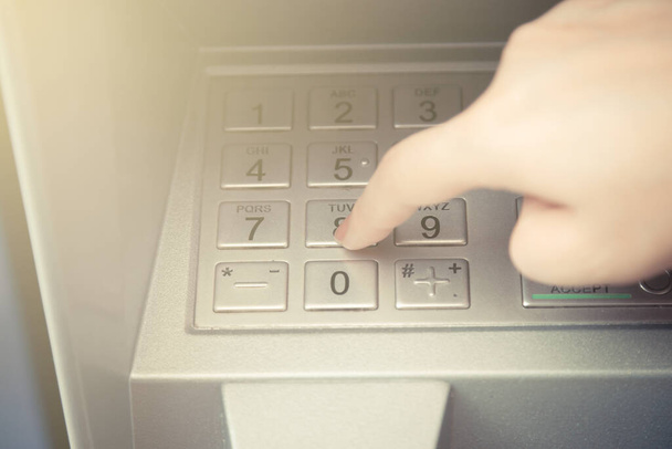 Primer plano de la mano introduciendo el código pin en el cajero automático para retirar su dinero - Foto, Imagen