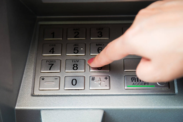 Primer plano de la mano introduciendo el código pin en el cajero automático para retirar su dinero - Foto, Imagen