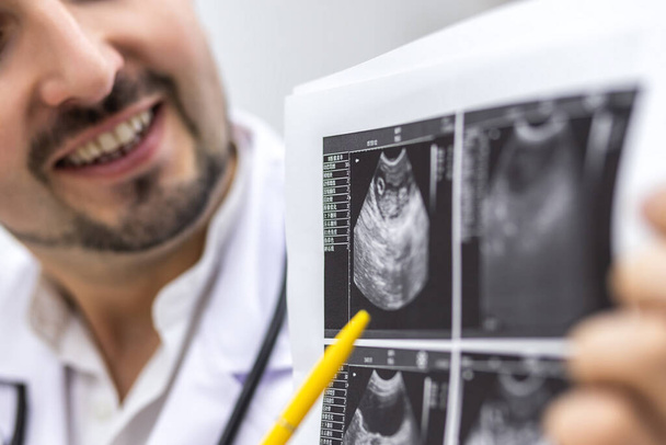 Cropped photo of a male doctor looking at ultrasound result. - Fotoğraf, Görsel