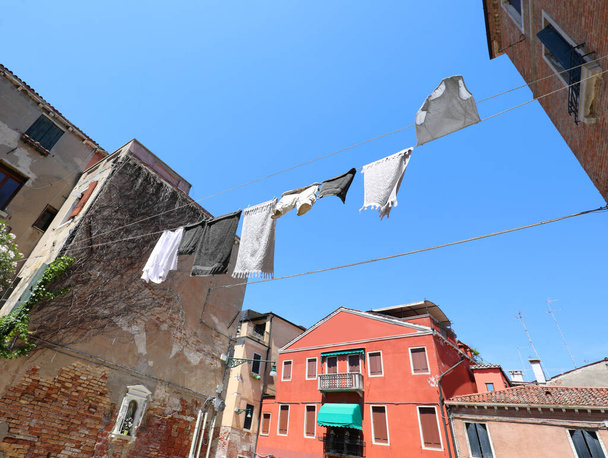 καθαρά ρούχα κρέμονται έξω για να στεγνώσει στον ήλιο σε μια μεσογειακή πόλη το καλοκαίρι - Φωτογραφία, εικόνα