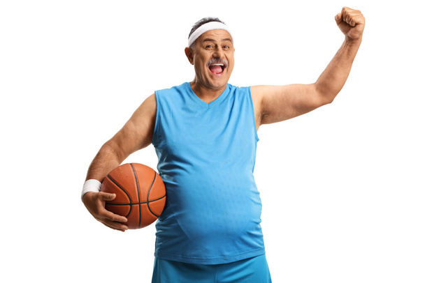 Happy mature man holding a basketball and gesturing with hand isolated on white background - Foto, Bild