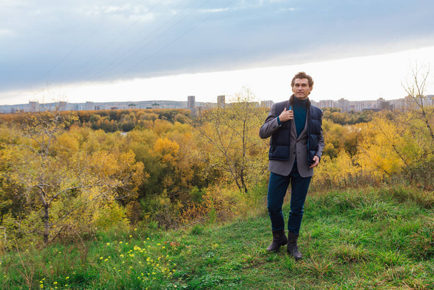 Tall handsome man walking outdoor in yellow autumn forest on the hill - Foto, imagen