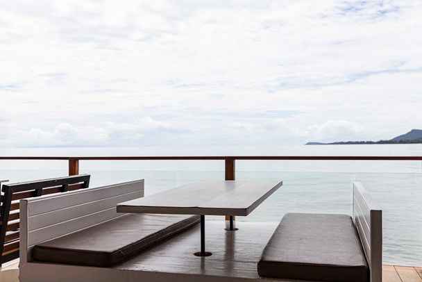 Lege bruine houten eettafel op terras aan zee - Foto, afbeelding