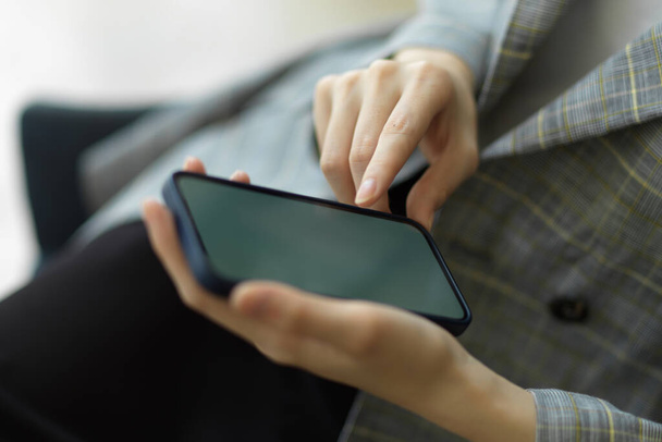 Szekrény, Üzletasszony használ okostelefon üres képernyő mockup, használata telefon és pihenjen munkanapok után - Fotó, kép