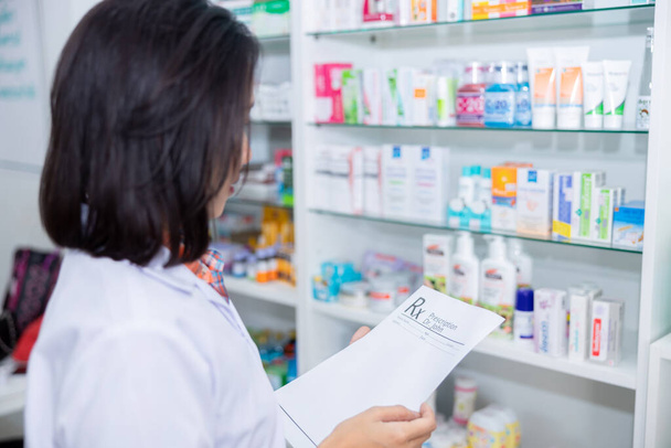 asiatique femme pharmacien contrôle médicament sur étagère dans pharmacie magasin Thaïlande - Photo, image
