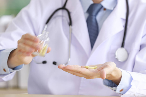 азіатський лікар капсули таблетки в скляній пляшці в руку
  - Фото, зображення