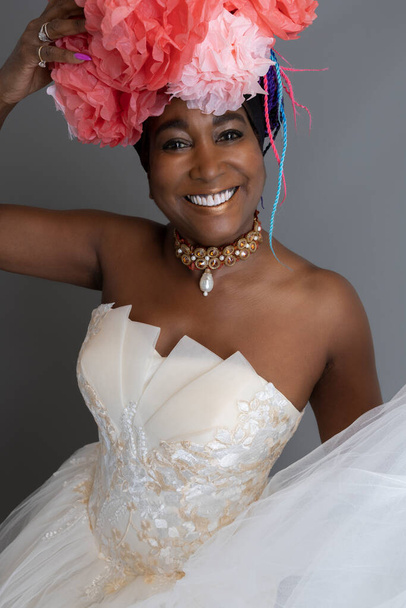 Улыбающаяся женщина в платье без бретелек и розовом бумажном головном уборе - Фото, изображение