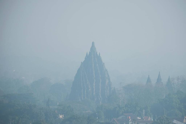 Yogyakarta, Indonesia, 14 settembre 2021. Silhouette dello storico edificio del Tempio di Prambanan visto da lontano in una mattina nebbiosa e nuvolosa. - Foto, immagini