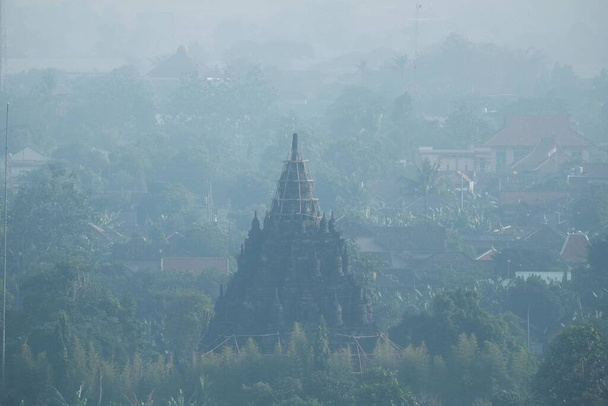 Yogyakarta, Indonésie, 14 sept. 2021. Silhouette du bâtiment historique du temple de Sojiwan vue de loin par une matinée brumeuse et nuageuse. - Photo, image