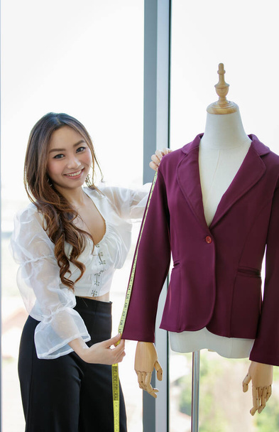 Woman fashion clothes shop owner working with dress and suite. - Photo, Image