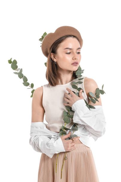 Beautiful young woman with eucalyptus branches on white background - Photo, Image