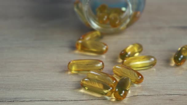 Omega 3 capsules d'huile de poisson d'or couché sur la table - Séquence, vidéo