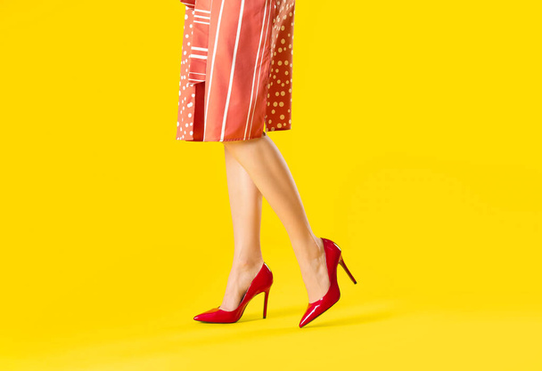 Krásná žena v vysokých podpatcích na barevném pozadí - Fotografie, Obrázek