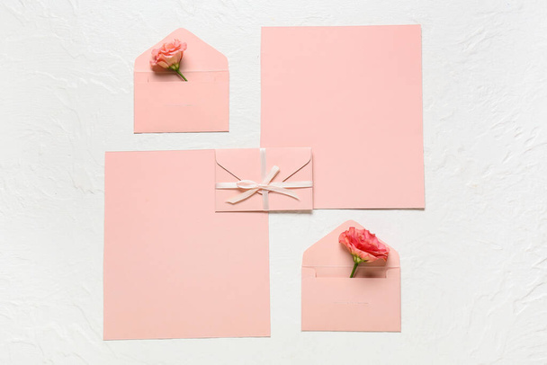 Blanco kaarten met rozen en enveloppen op witte achtergrond - Foto, afbeelding