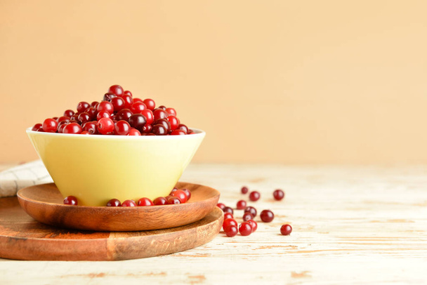 Bowl with healthy cranberry on light wooden background - Foto, Imagen