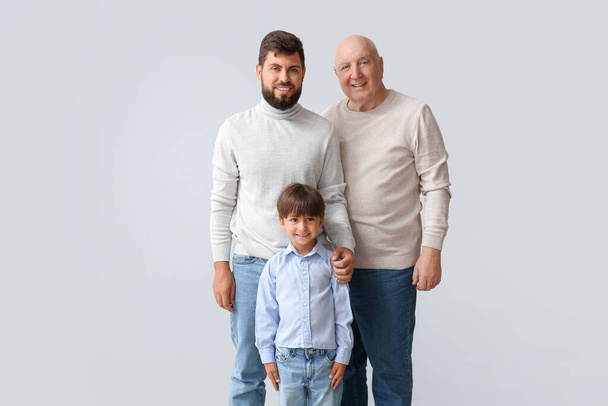 Happy man, his little son and father on light background - Φωτογραφία, εικόνα