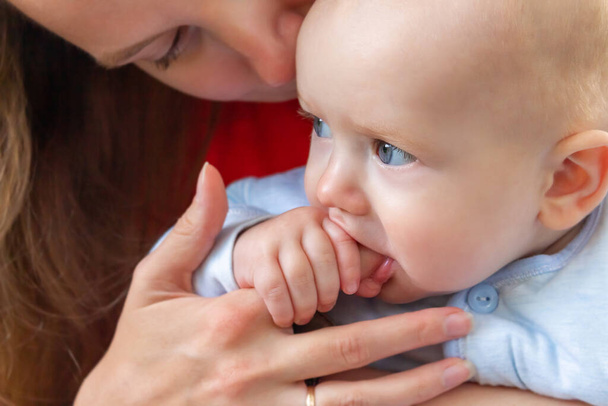 Little baby holding mothers finger in mouth. - Φωτογραφία, εικόνα